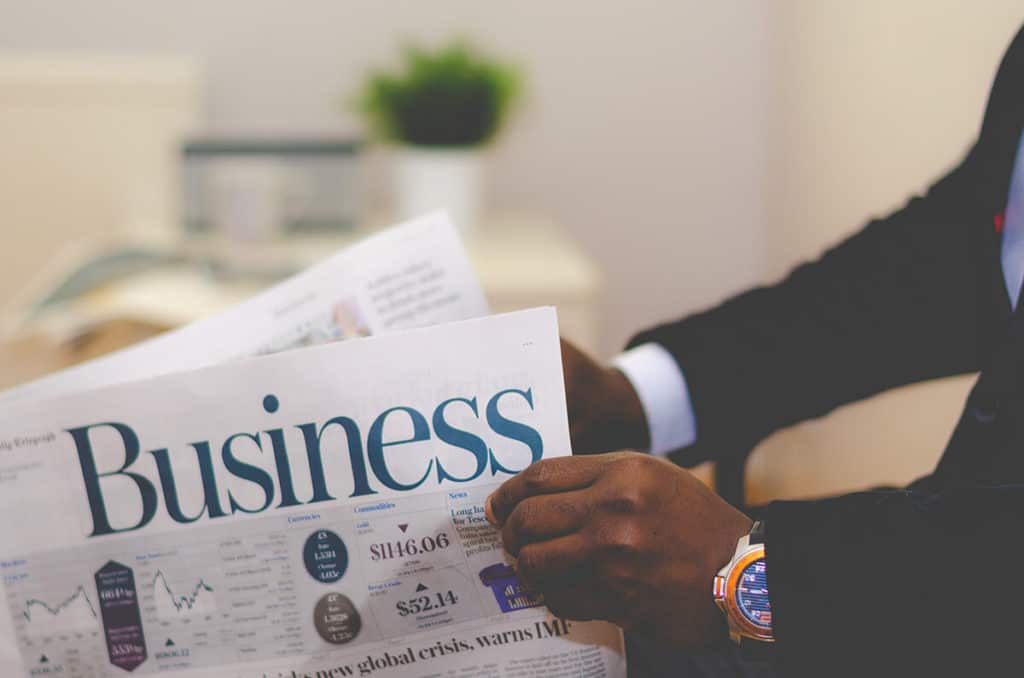 Close up image of a man holding a newspaper